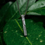 "Campania Necklace" necklace, featuring a pendant with sodalite and Damascus styling, set against a natural green backdrop.