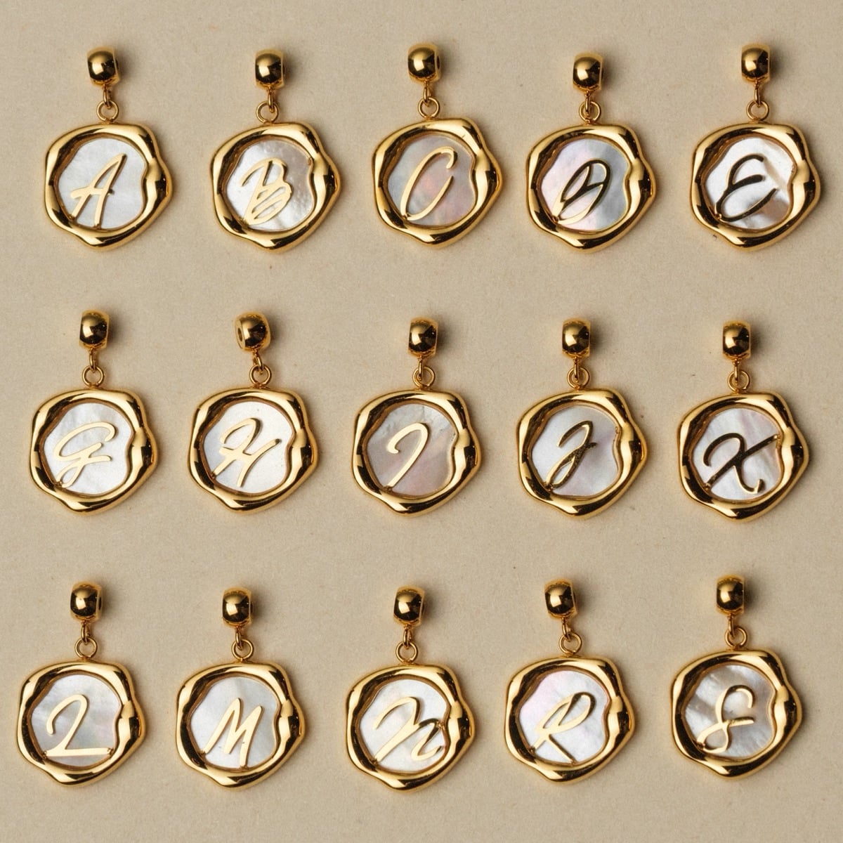 "Letter Charm A-Z", gioiello in stile nacre e oro con stile elegante.