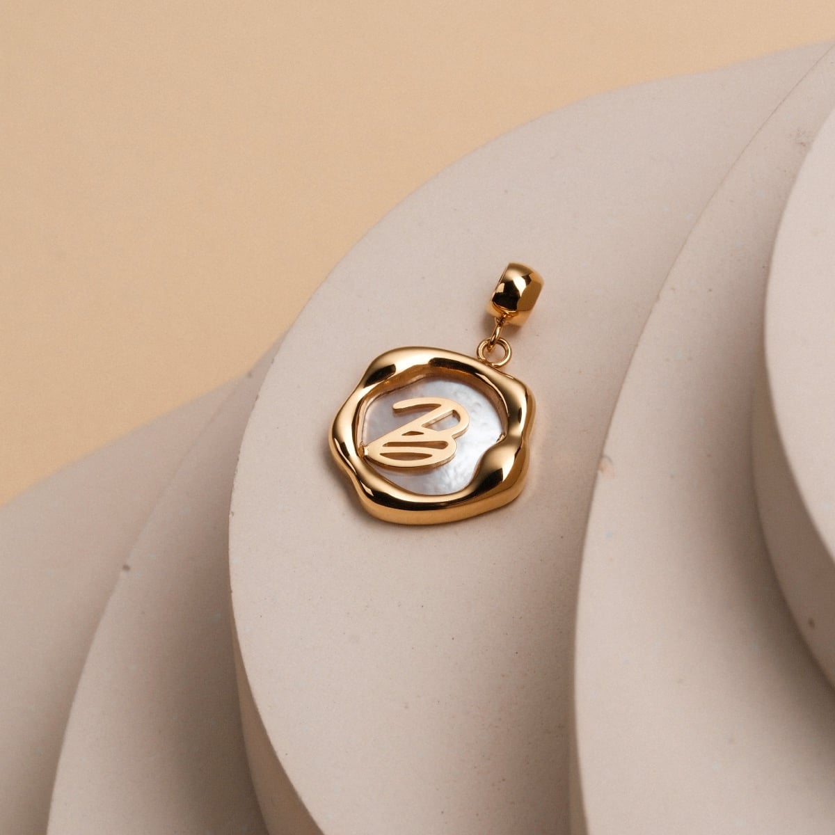 Letter Charm A-Z: Un fascino letterale elegante in nacre e oro con un design elegante e moderno.