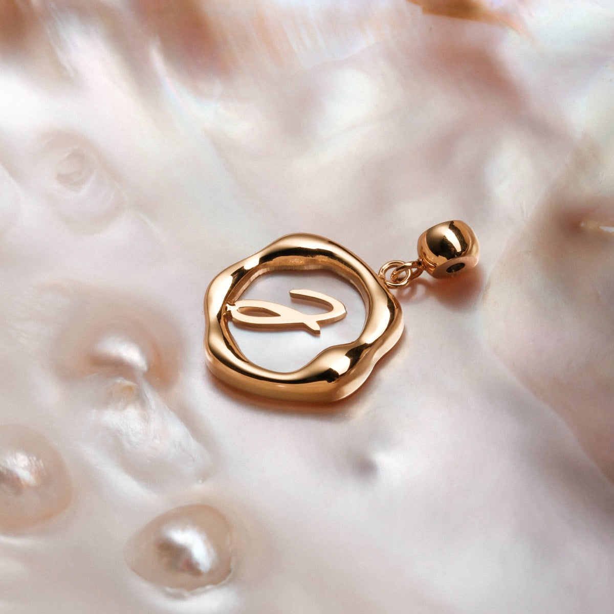 "Letter Charm A-Z" fascino lettera d'oro su sfondo nacre, design elegante e elegante.