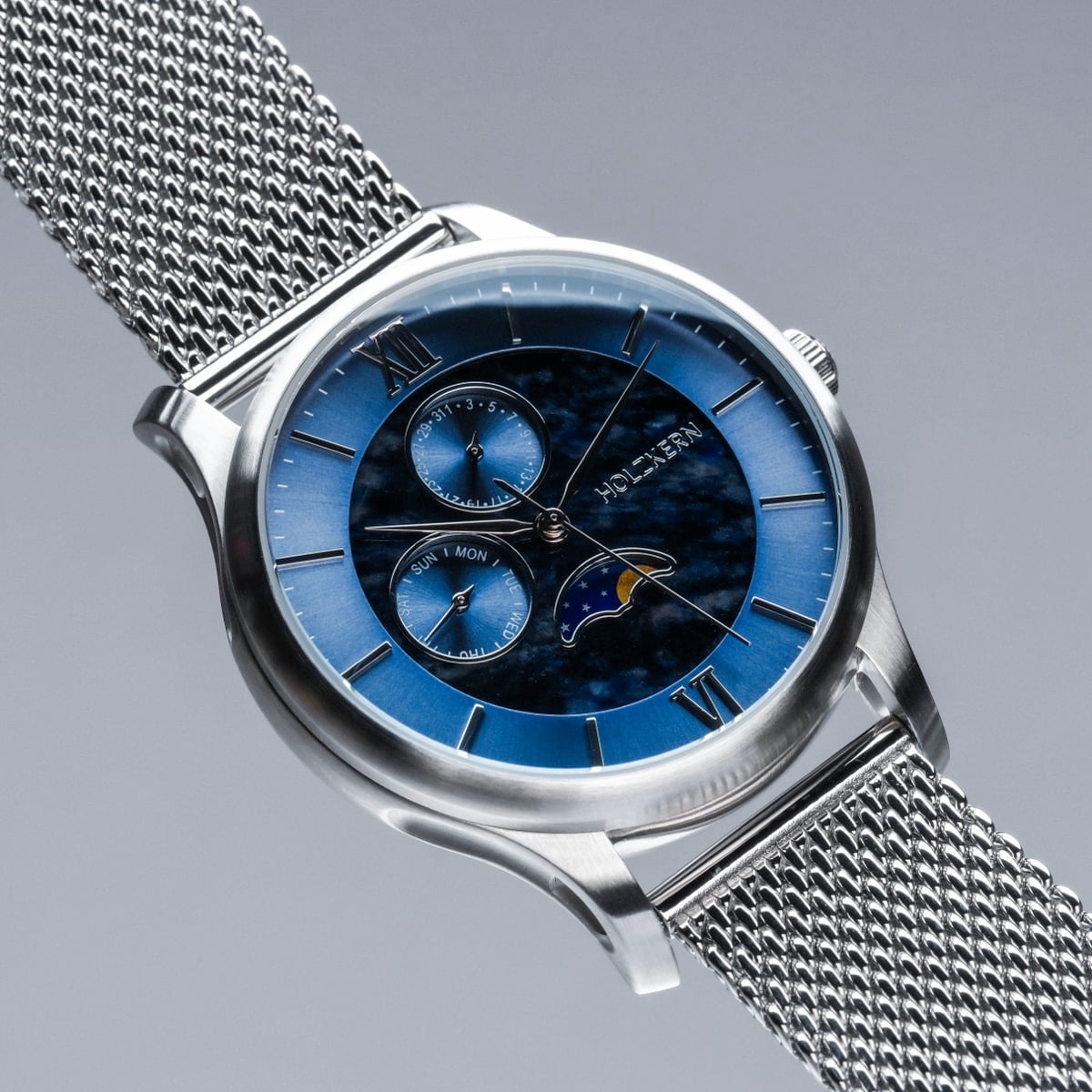 "Moonrise", orologio in marmo e argento con un quadrante blu e cinturino in mesh, che mostra un design sofisticato.