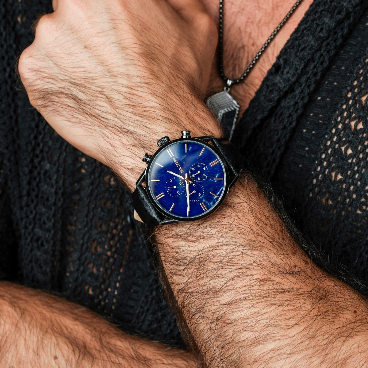 Orologio "Gifted" con un viso sodalite-blue e cinturino in pelle nera, indossato su un polso per un look elegante.