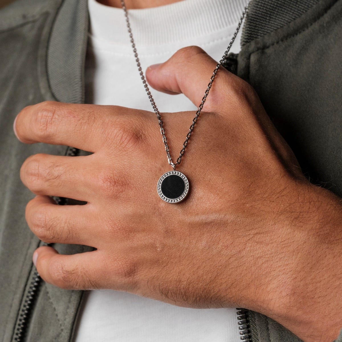 "Interplay Necklace", a sophisticated necklace with black marble and silver accents, worn casually.