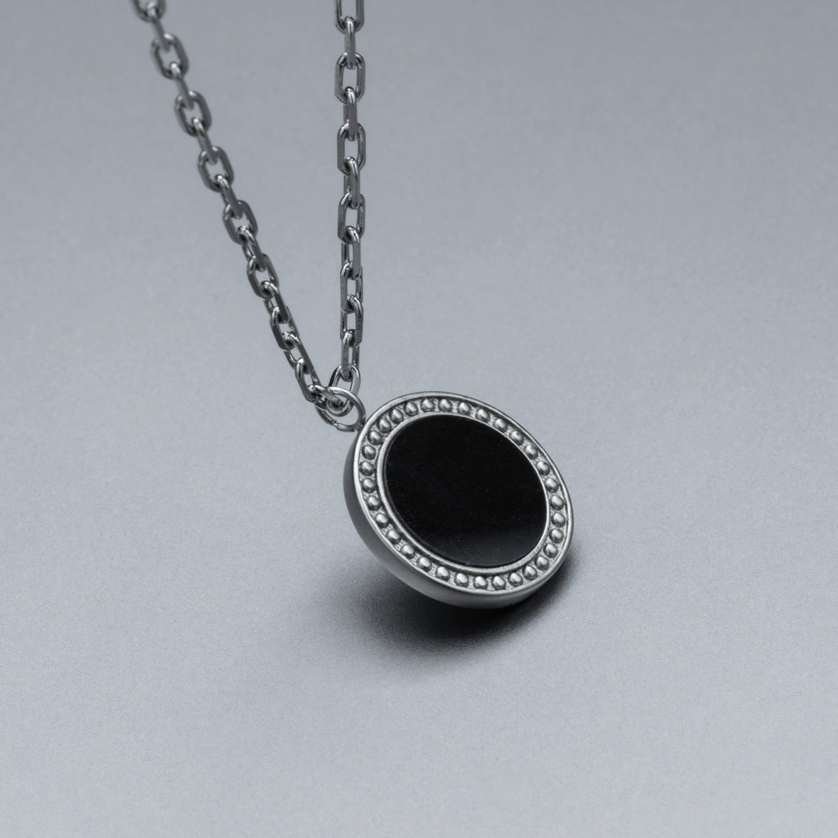 "Interplay Necklace", a necklace featuring black marble and silver with an elegant, minimalist design.
