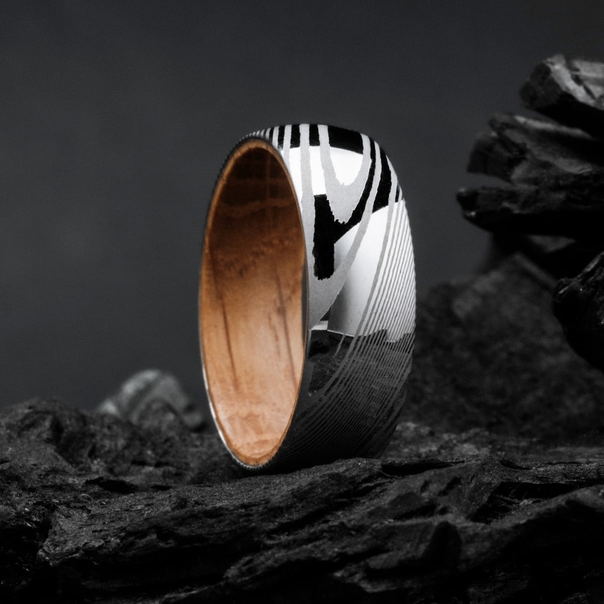"Sumo Ring": A striking ring featuring a blend of oak interior and Damascus steel exterior, showcasing a bold, elegant style.