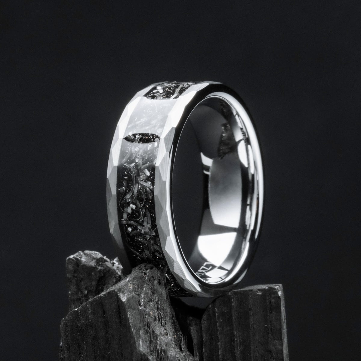 "Sumo Ring" - A tungsten ring with a meteorite inlay, featuring a faceted, reflective design on a dark background.