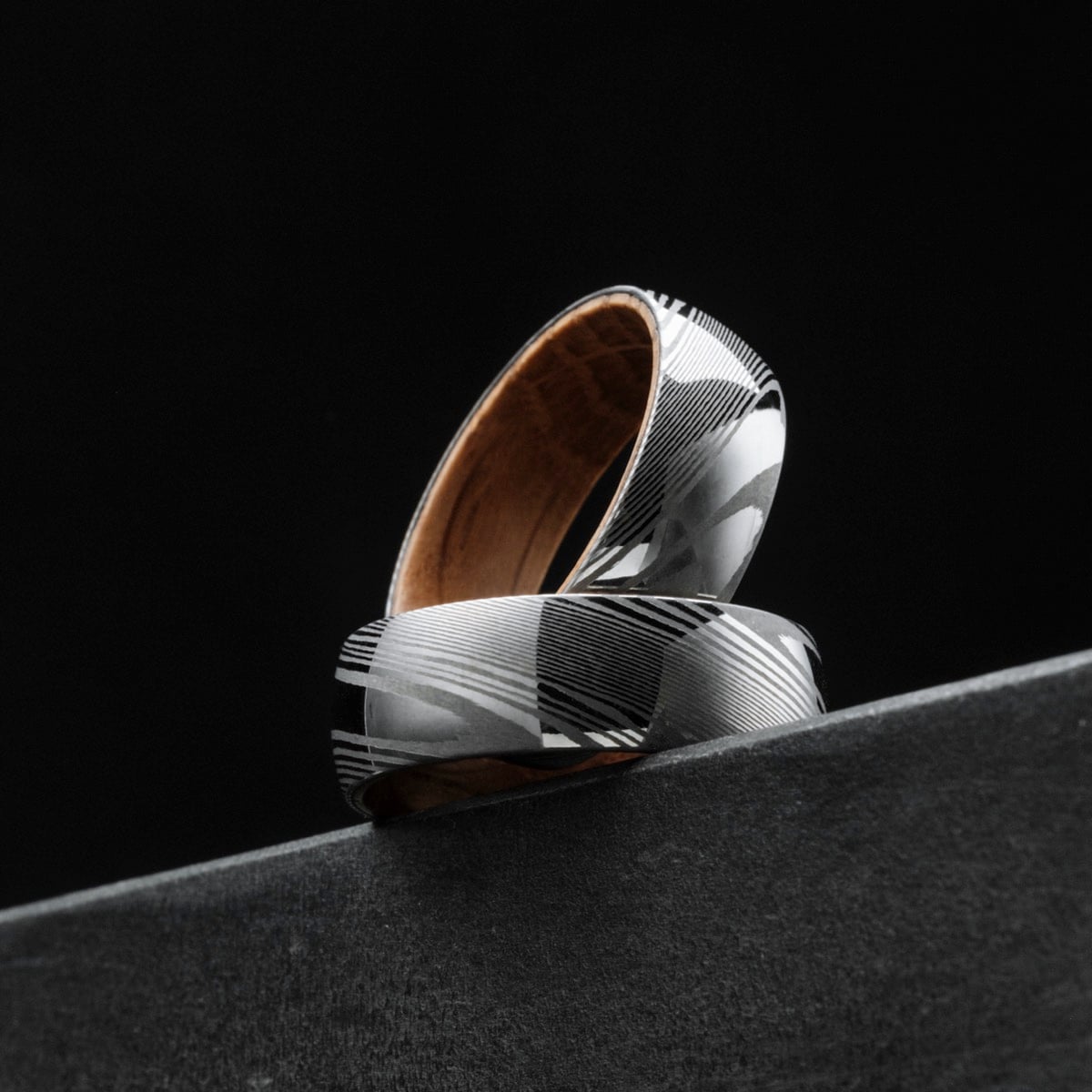 "Sumo Ring", a stylish ring crafted from oak and Damascus, showcasing a modern geometric design.