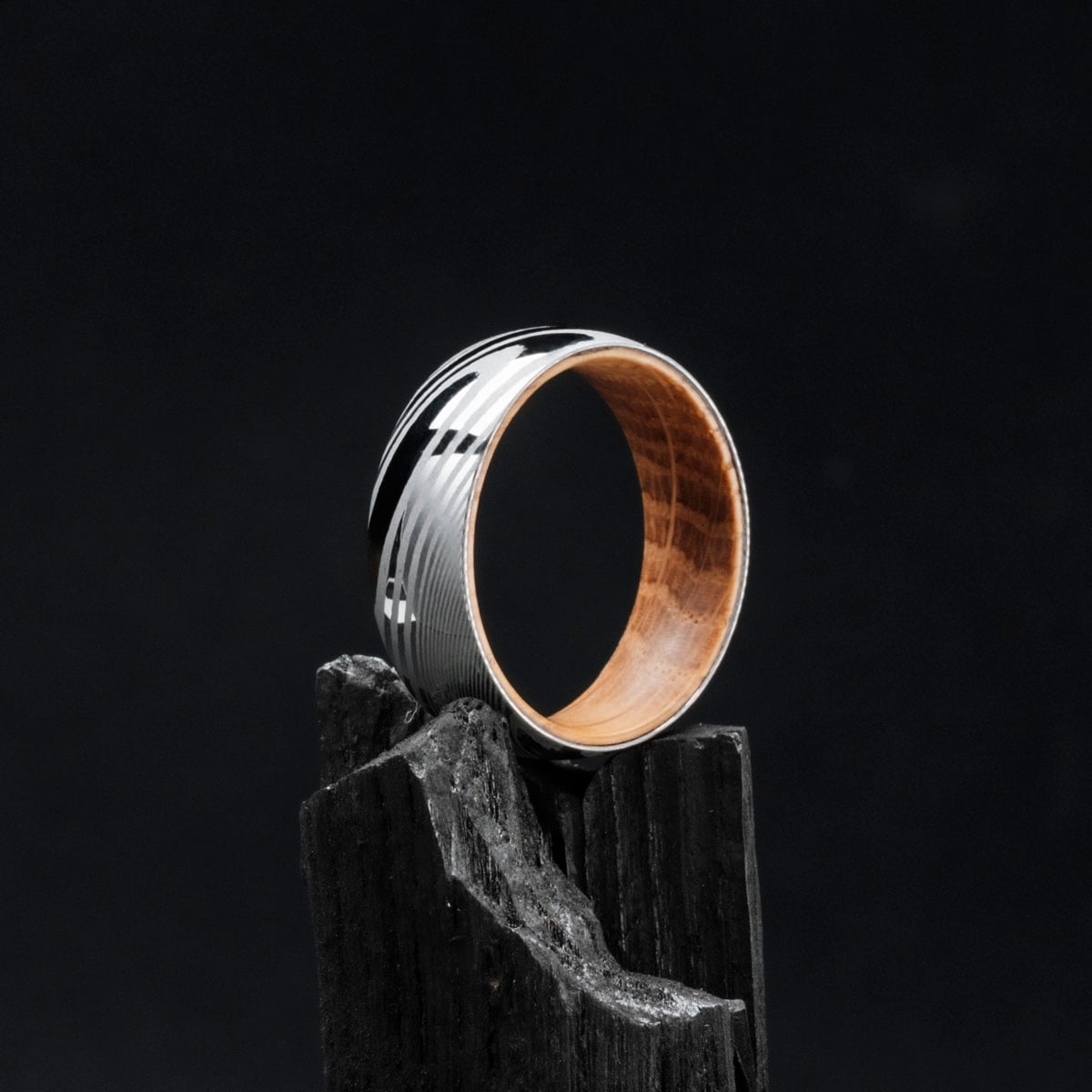 "Sumo Ring" ring with oak interior and Damascus steel exterior, featuring an elegant and modern design.