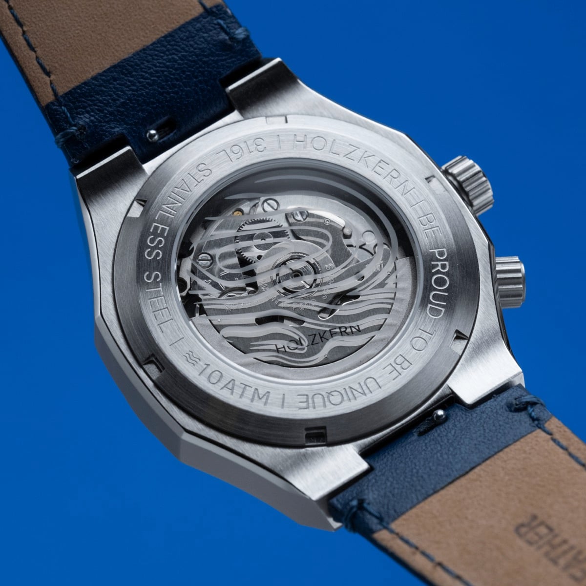 "GMT Cloudhopper" watch with stainless steel back, marble accents, and blue leather strap.