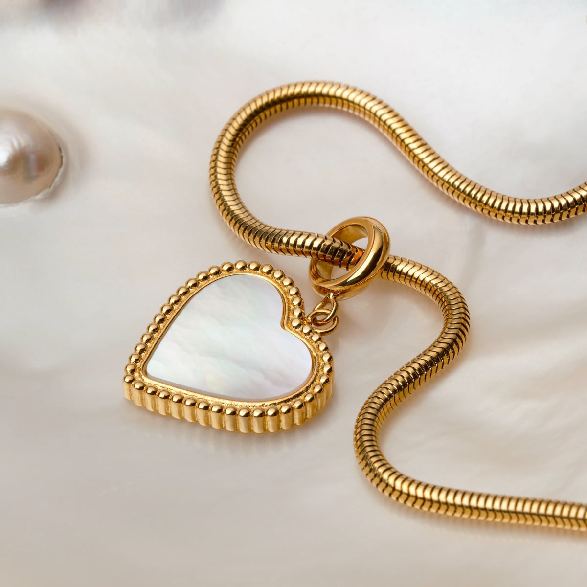 Collana "Amorance" con pendente a forma di cuore e catena in oro, con un design elegante e lussuoso.