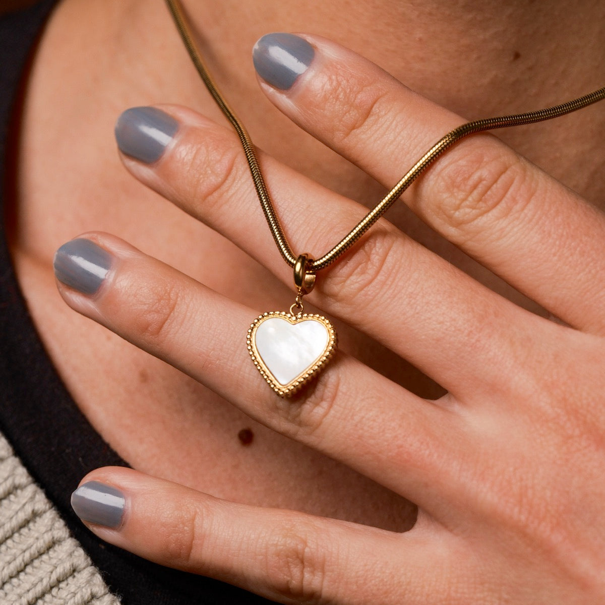 Collana "Amorance" che mostra un pendente a forma di cuore in oro, indossato elegantemente sulla clavicola.