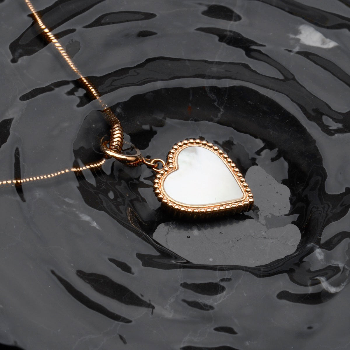 "Collana di ammonimento", una collana a forma di cuore elegante con accenti in oro rosa e grigio.