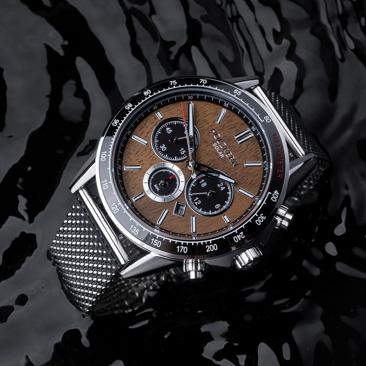 Orologio "Comfort Crusher" con quadrante in noce e accenti in argento, progettato con stile contro una superficie nera riflettente.