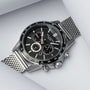 "Comfort Crusher", un elegante orologio con un quadrante acero e una fascia in mesh argento.