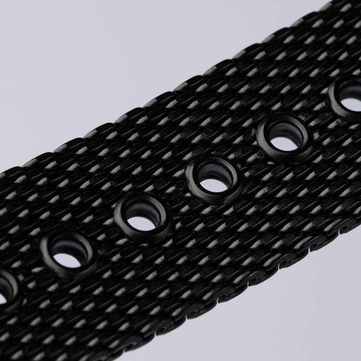 "Comfort Crusher", cintura nera con texture con fori circolari e accenti di design in marmo.
