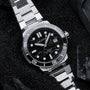 Orologio "Deepdiver" in marmo e argento, con un design elegante e sportivo con quadrante nero e bracciale in metallo.