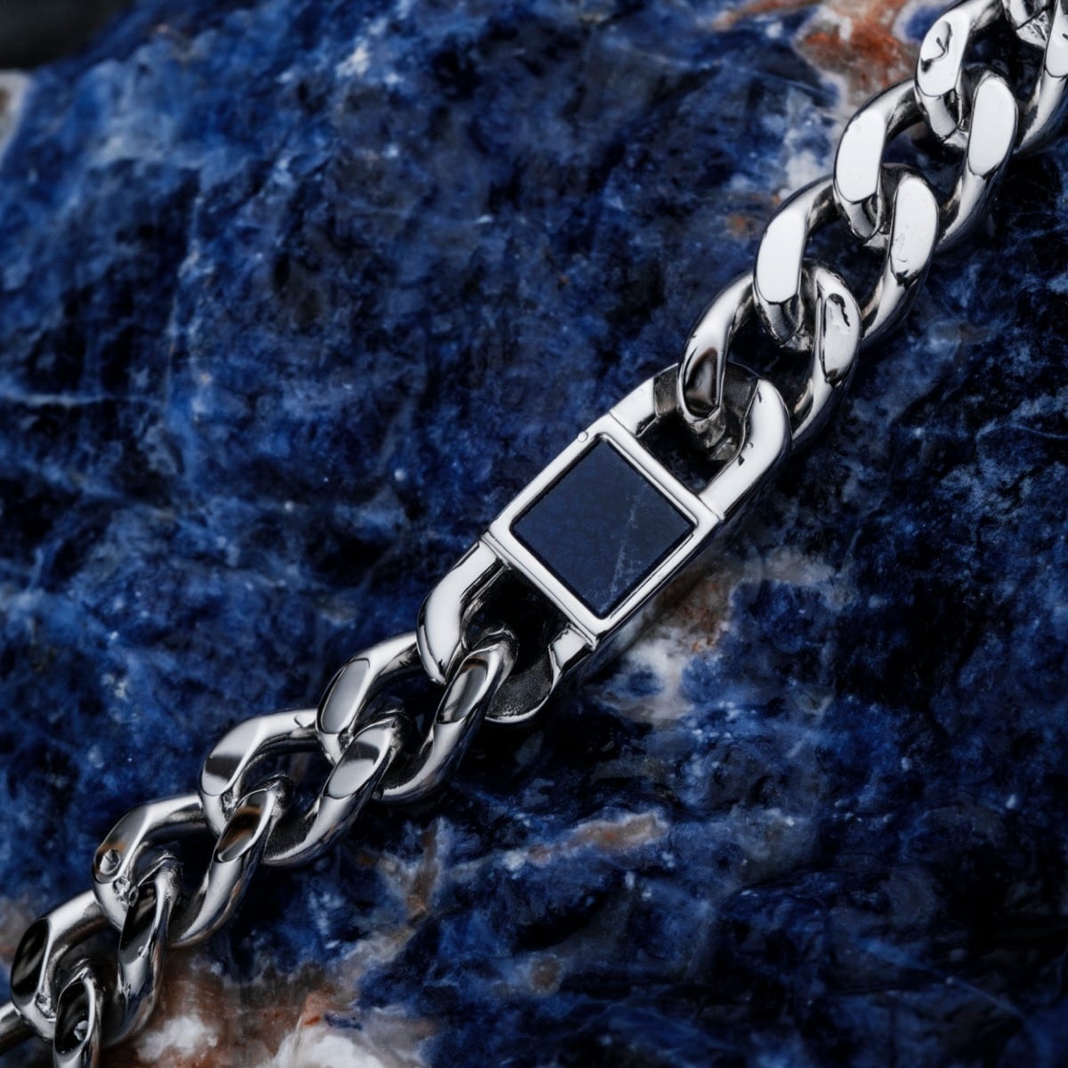 "Bodyguards Strap", a stylish silver strap with a marble design, set against a textured blue stone background.