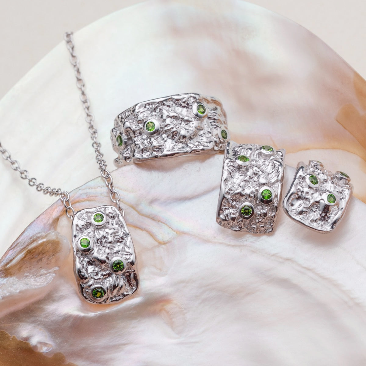 "Silverstream Earrings" earrings, featuring silver with diopside accents, showcasing a textured and elegant design.