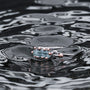 "Silverstream Earrings, elegant earrings in aquamarine and rosegold, showcased on rippling water for a serene touch."