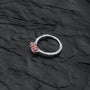 "Silverstream Ring, artisan ring with rose quartz and rosegold, featuring a textured finish on a dark surface."