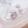 "Silverstream Earrings: Elegant rosegold earrings with aquamarine accents, showcasing a sophisticated and delicate style."