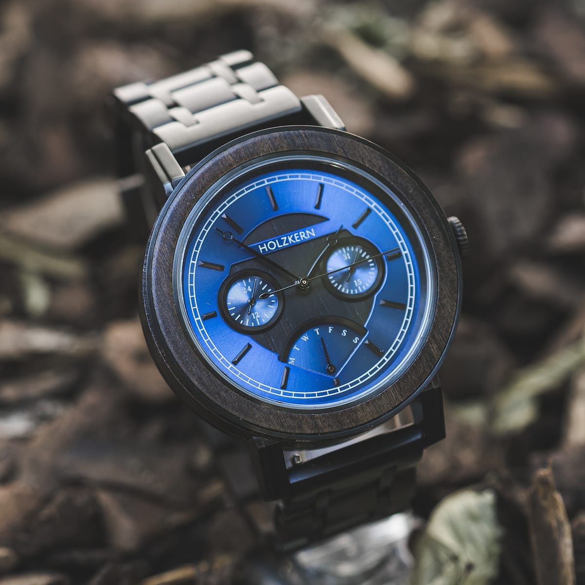 "Belize" watch featuring a striking blue dial and elegant leadwood accents, set against a natural backdrop.
