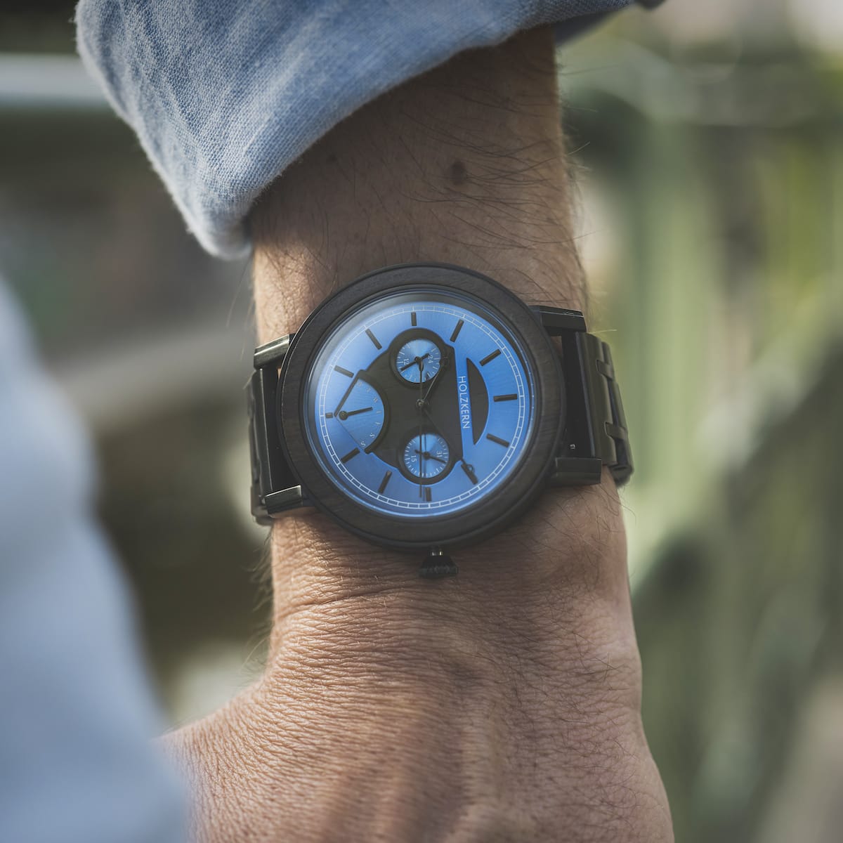 "Belize" watch with sleek black leadwood design and vibrant blue dial.