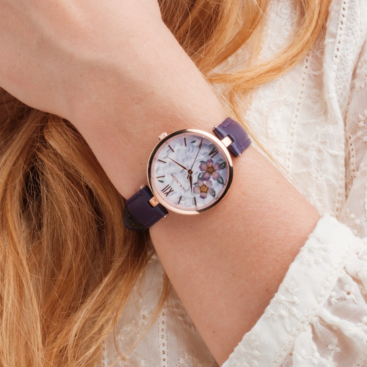 "Everbloom", elegante orologio con design floreale con fiori di prugna e accenti viola sul polso.