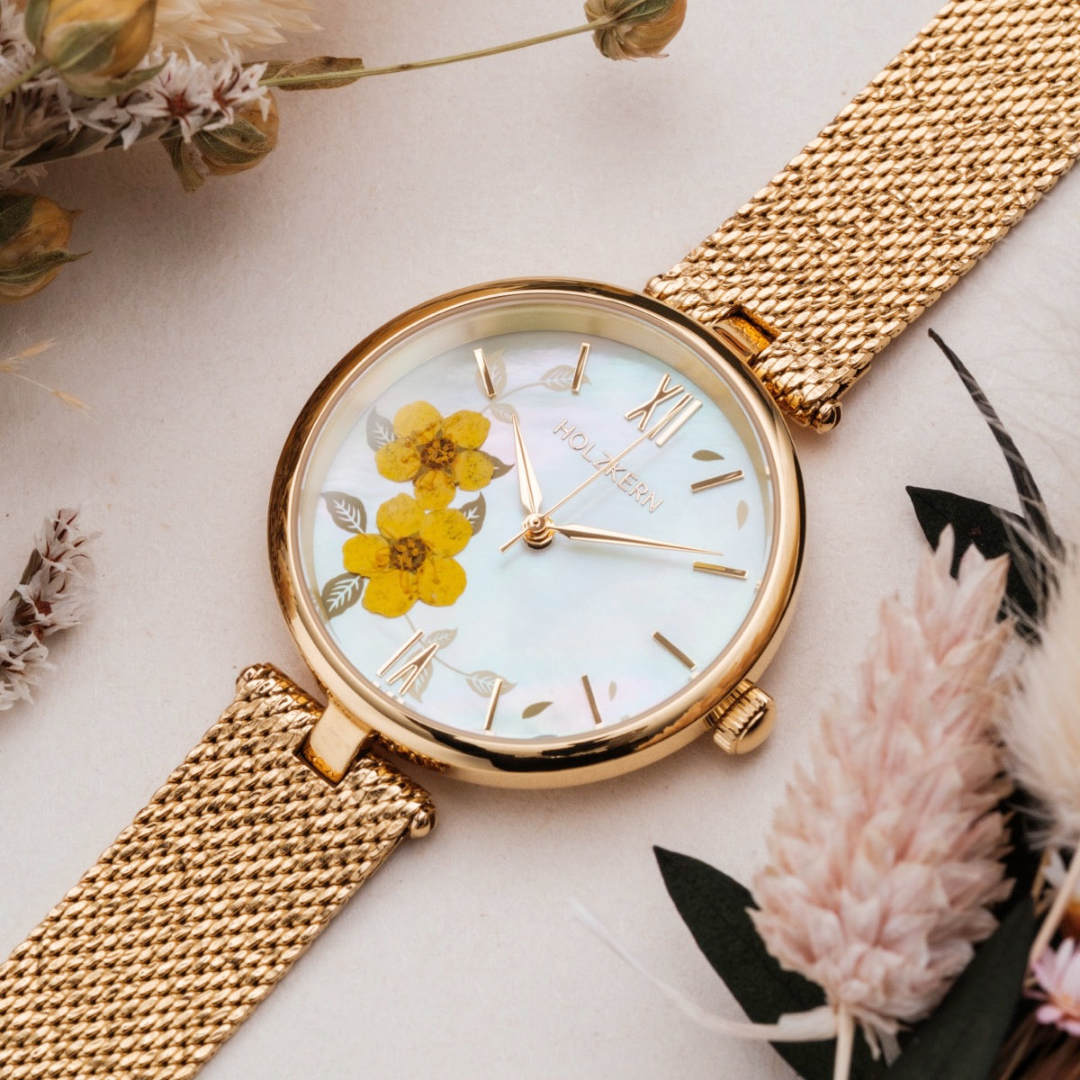 Orologio "Everbloom" con design floreale, accenti d'oro e stile elegante.