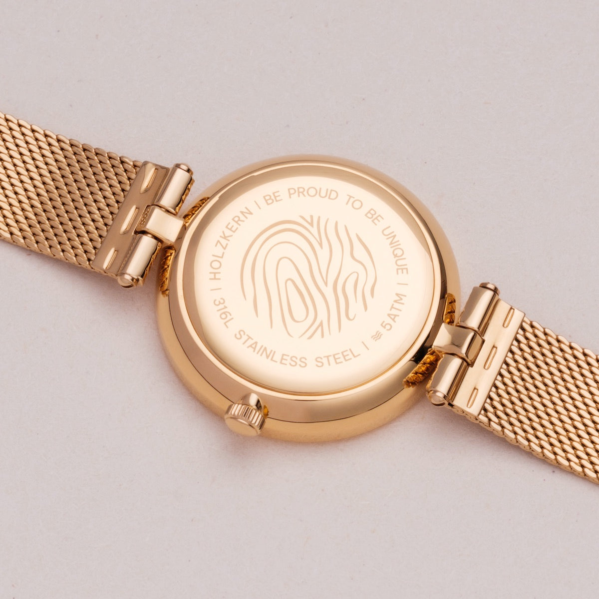 Orologio "Everbloom" con fiori di prugne e tonalità d'oro, con un design elegante e moderno.