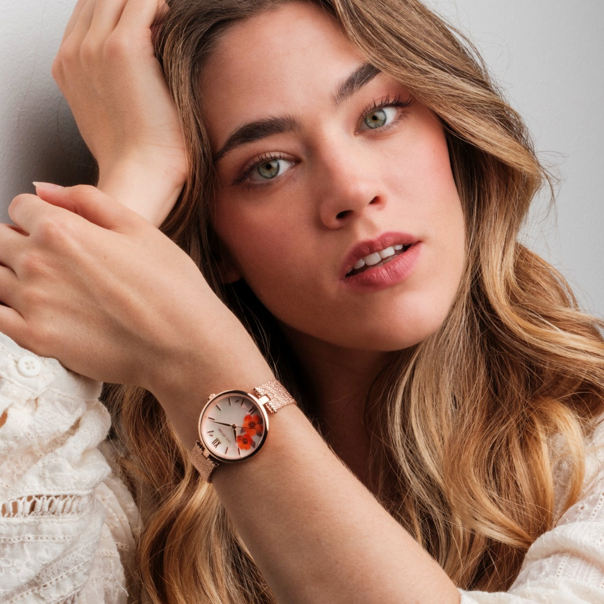 Orologio "Everbloom" in oro rosa con un design di quadrante a fiori di prugna, indossato su un polso elegante.