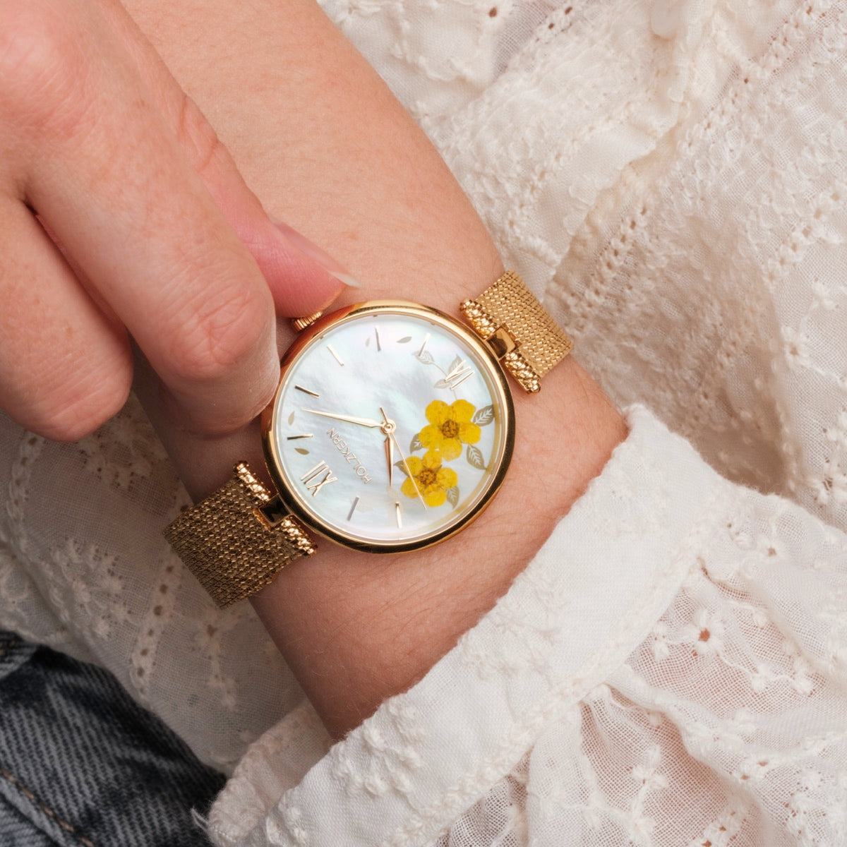 Orologio "Everbloom" con una delicata fascia d'oro e accenti floreali elegantemente sul quadrante.