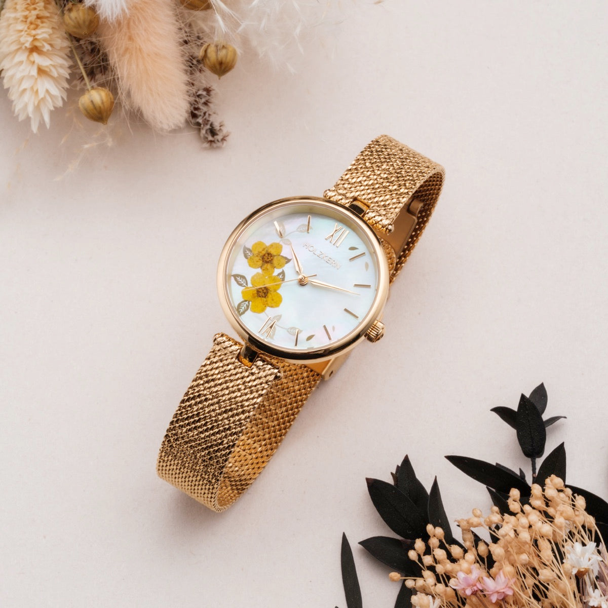 Orologio "Everbloom" con una fascia in mesh oro e un design in fiore di prugne in uno stile floreale delicato.