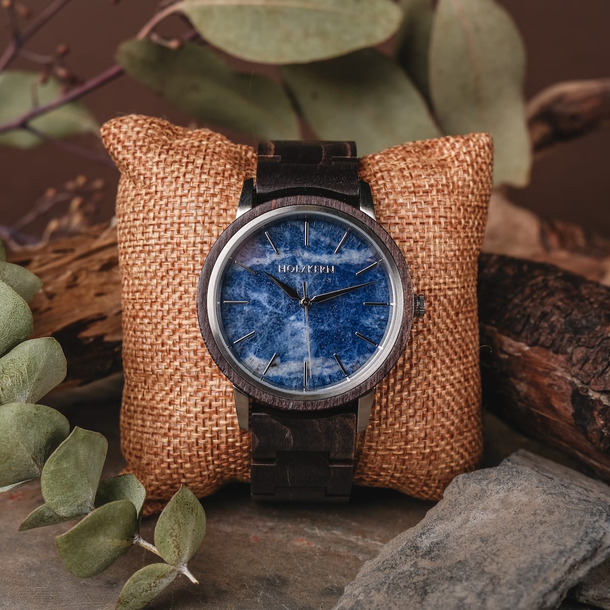 Orologio "Immanuel" con un sorprendente viso sodalite blu e ricchi accenti acero, in stile su un cuscino in grafite rustico.