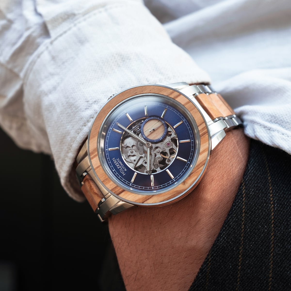 "Haiku" watch featuring a skeletal dial design and a stylish olive-toned bezel and strap.
