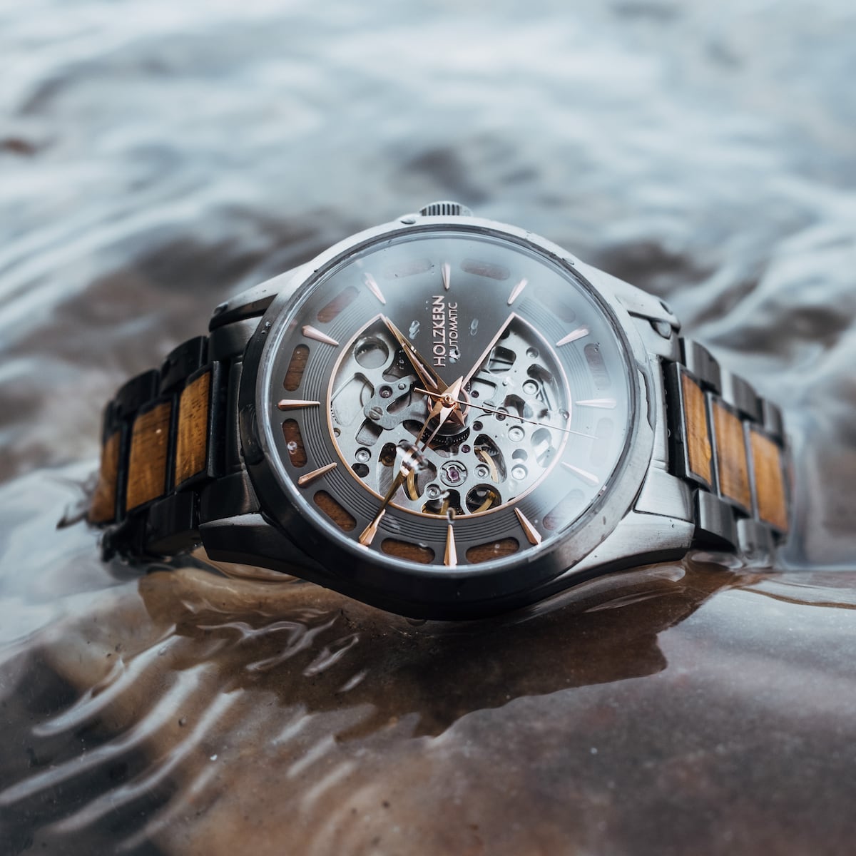 "Tenoumer" watch featuring a koa wood and dark grey design with a stylish skeletal dial.