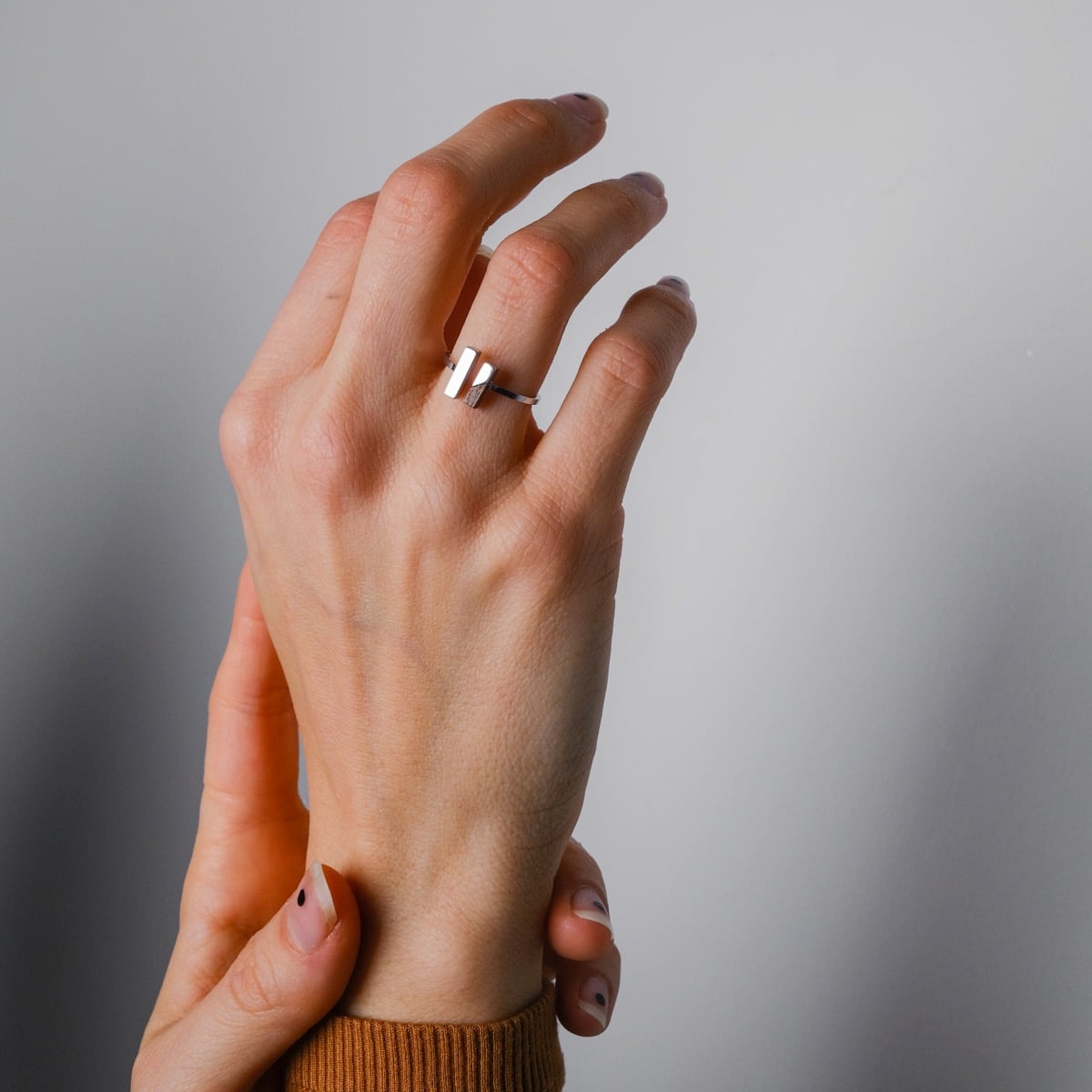 "Campania Ring", a stylish walnut and silver ring, elegantly worn on a hand.