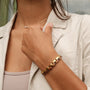 Bracciale "Duet", caratterizzato da un sofisticato design in zebrawood e oro sul polso di una donna.