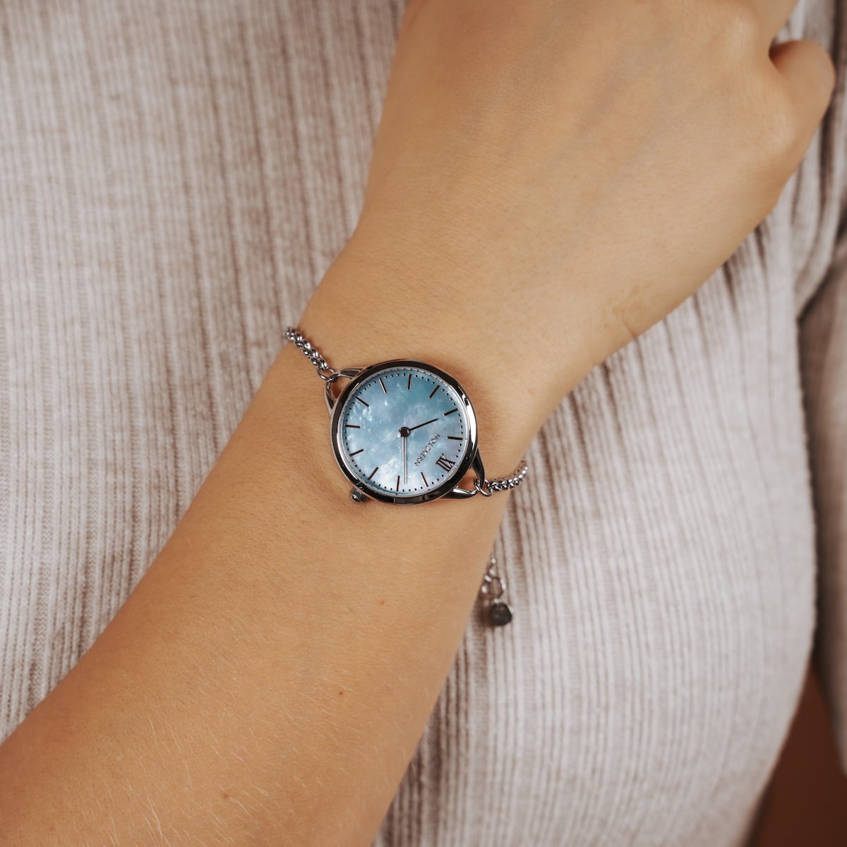 Orologio "Brighter", con accenti in argento e quadrante nacre, riflettendo lo stile elegante su un polso.
