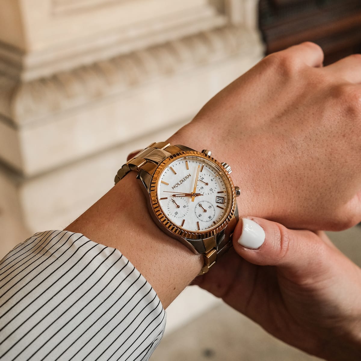 Orologio "The Supportive" in nacre e oro, design elegante e sofisticato sul polso.