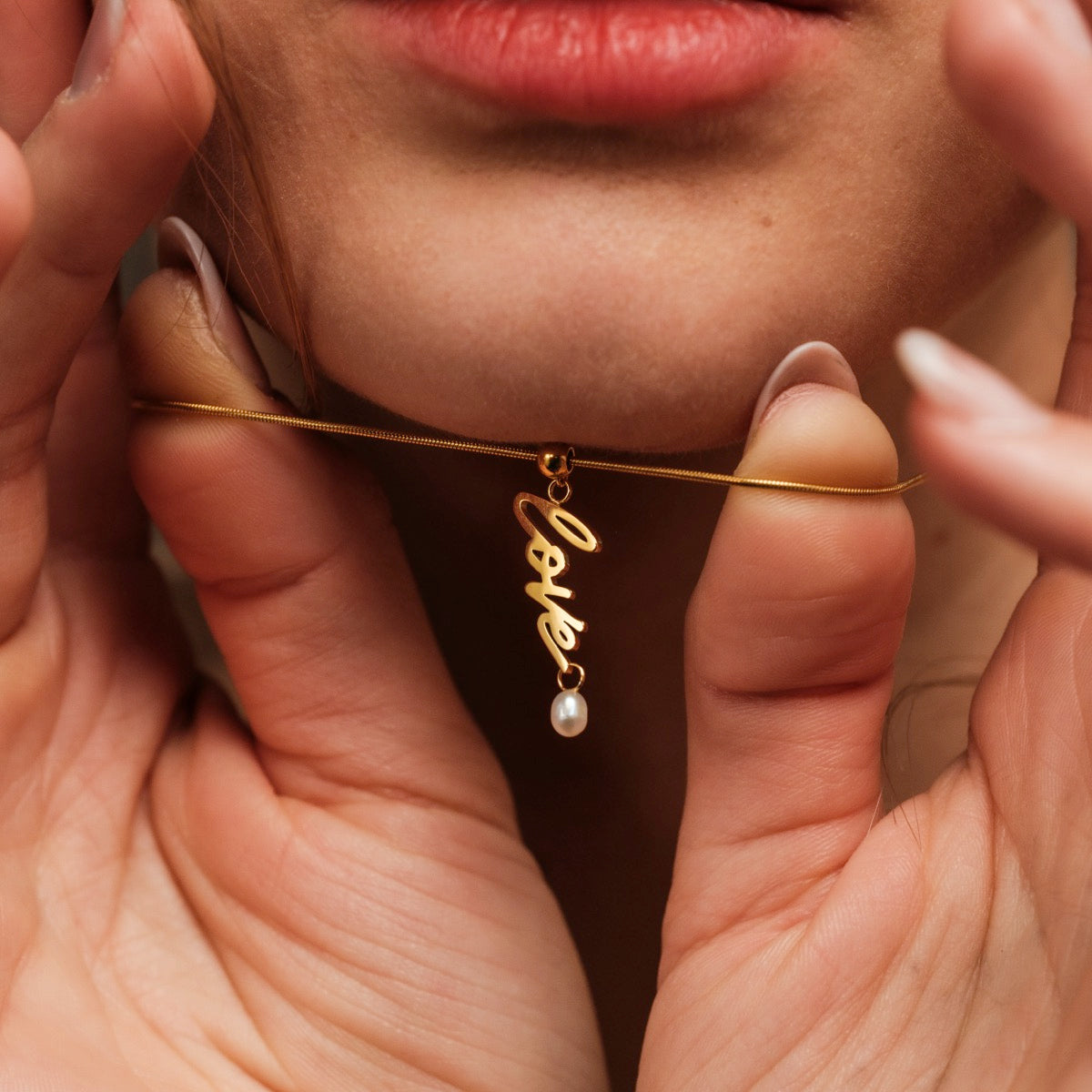 "Love-Charm", una collana d'oro e perla, elegantemente in stile con un fascino di script "amore".
