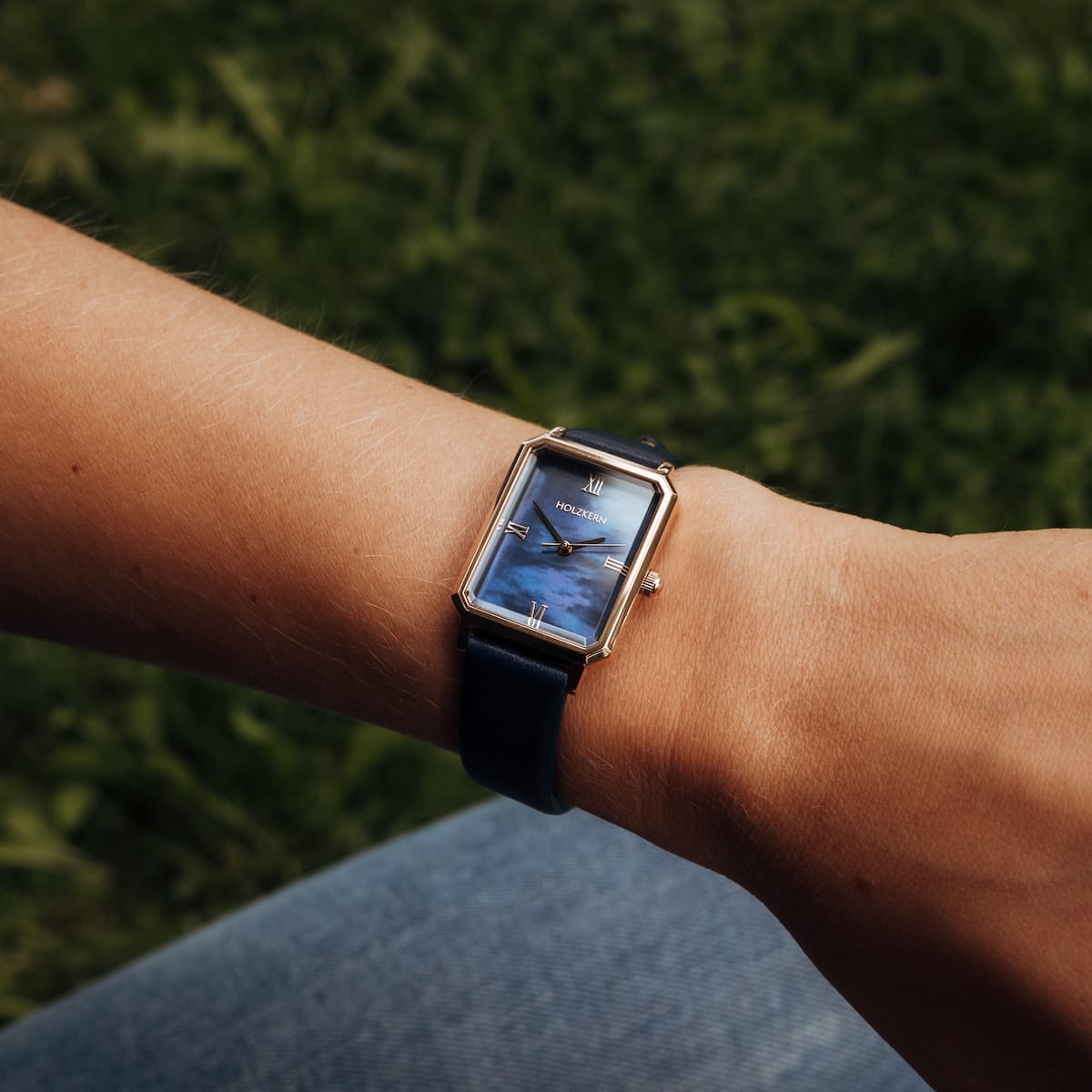 "Sapientia" watch with rectangular nacre dial and rose gold accents on wrist.