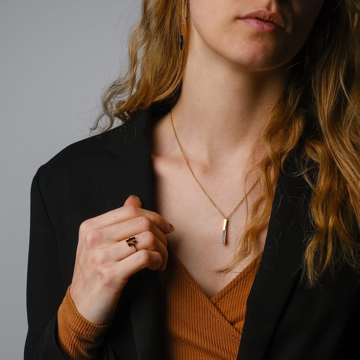 "Campania Earrings earrings, elegant with a marble and gold design, complementing a sophisticated outfit."