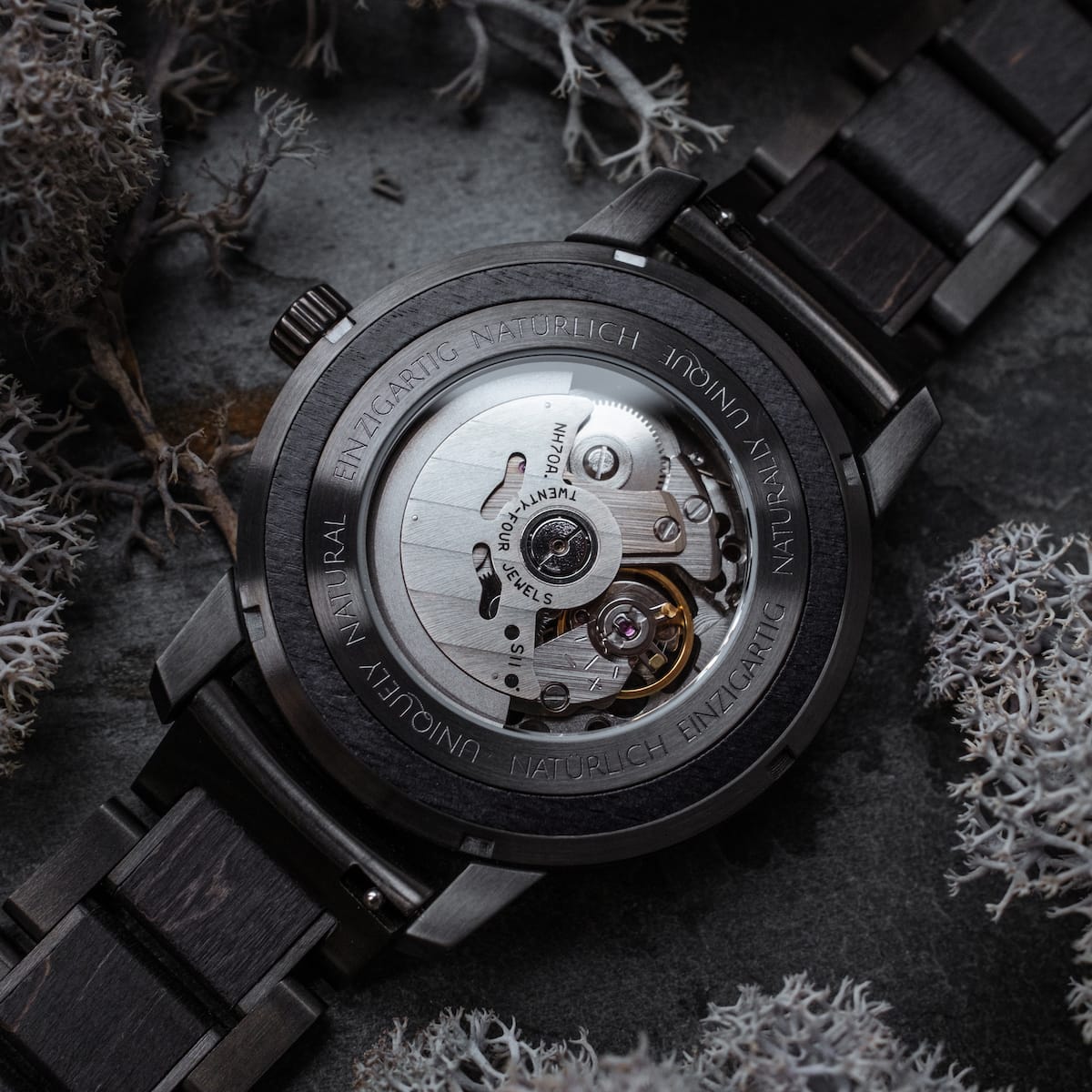 Orologio da polso in carbonio con finitura acero grigio scuro e design meccanico intricato.