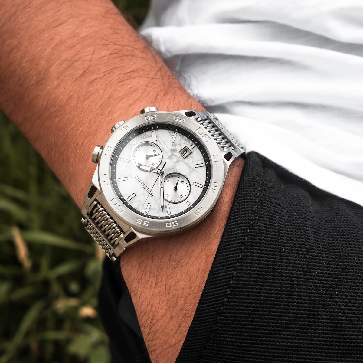 Orologio "Elqui" con un volto in marmo e accenti in argento, che mostrano un design elegante e moderno sul polso.
