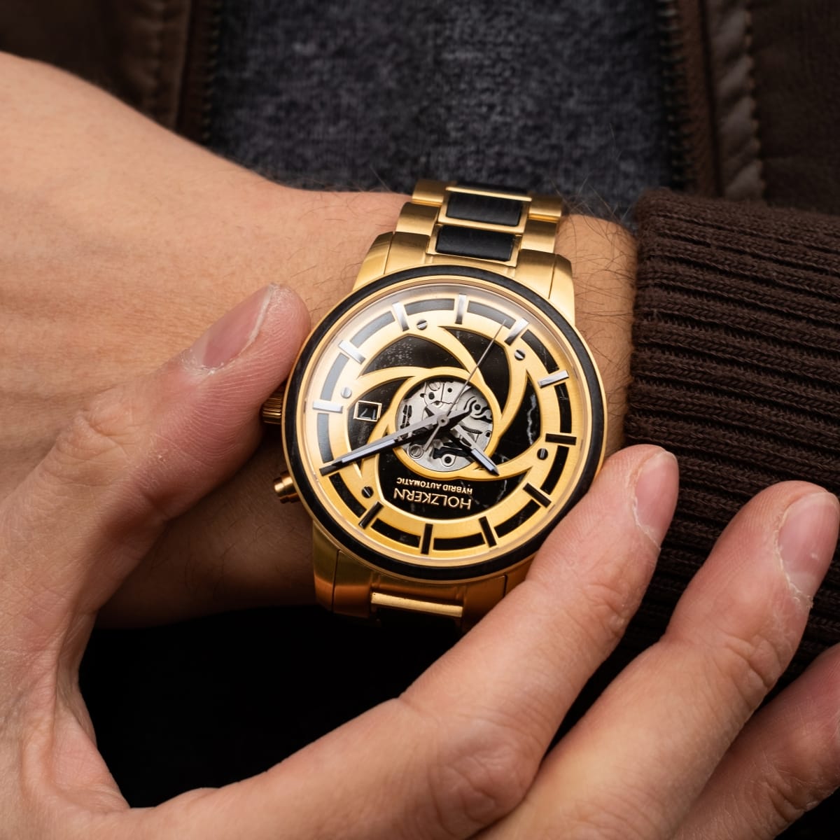 "Cyclonic" watch with a gold-tone finish and intricate dial design, showcasing a maple and marble aesthetic.