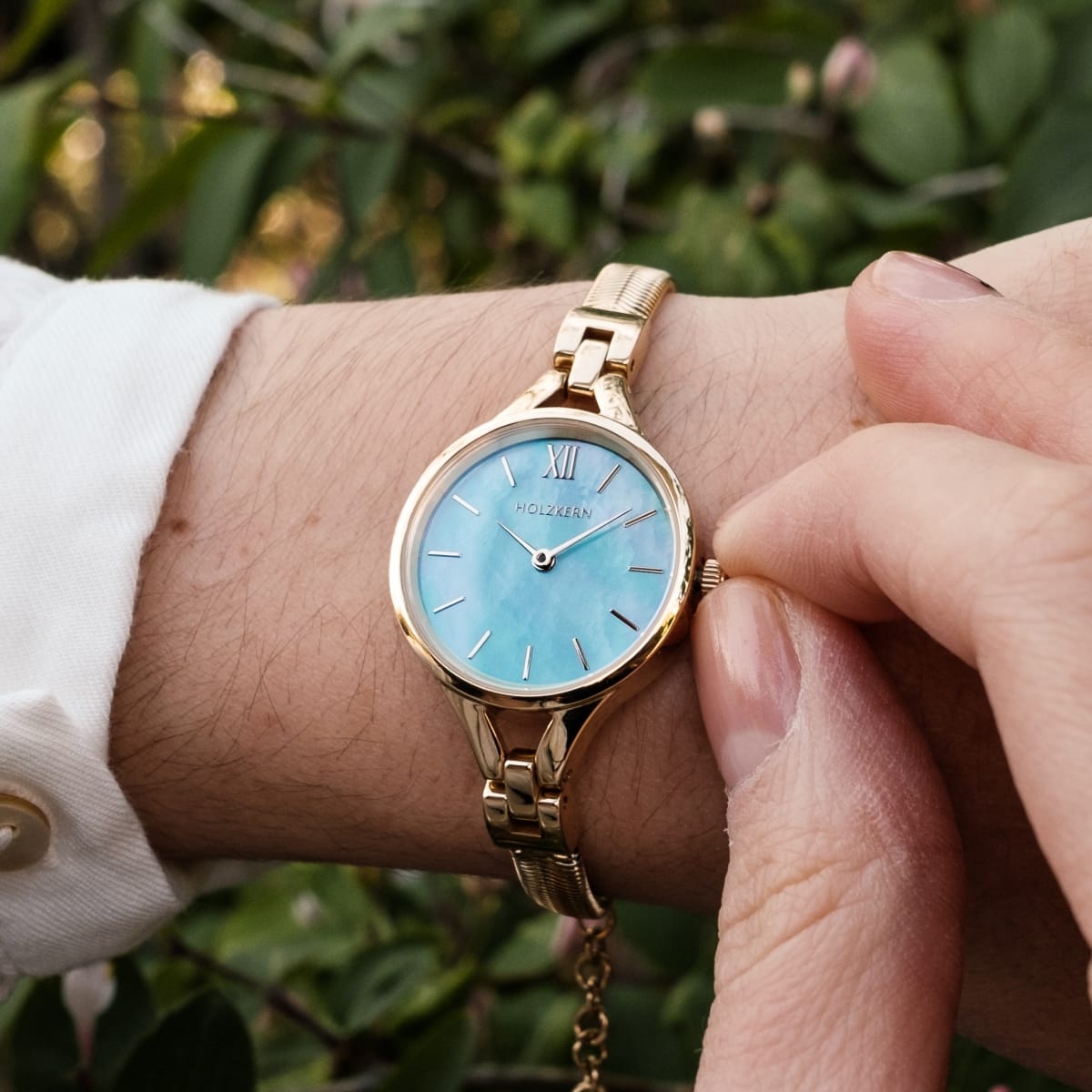 "Shesha" orologio con un design a oro e un viso blu nacre, catturando uno stile elegante e senza tempo.