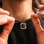 Collana "Scalar Collana" con un design in marmo e oro elegantemente eroe da una persona.