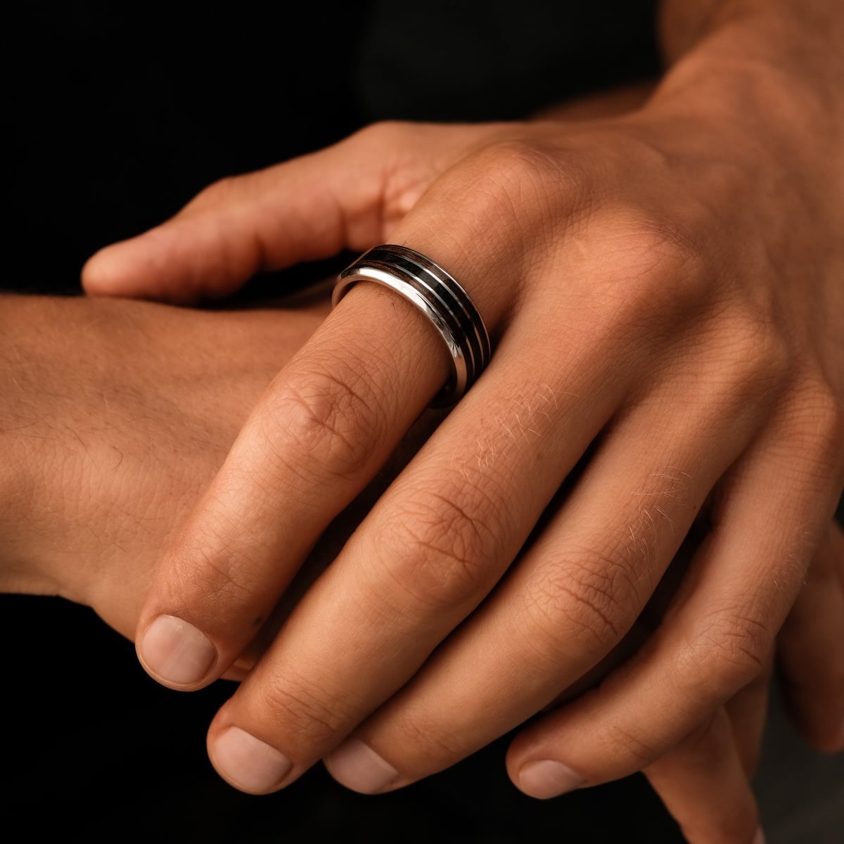 "Cartesian Ring" ring, featuring a walnut and silver design, showcased on a hand with a sleek, modern style.