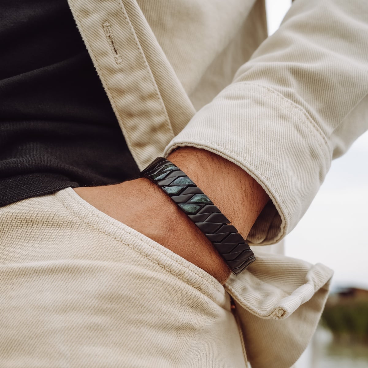 "Baritone" bracelet in a sleek marble and black style, worn casually.